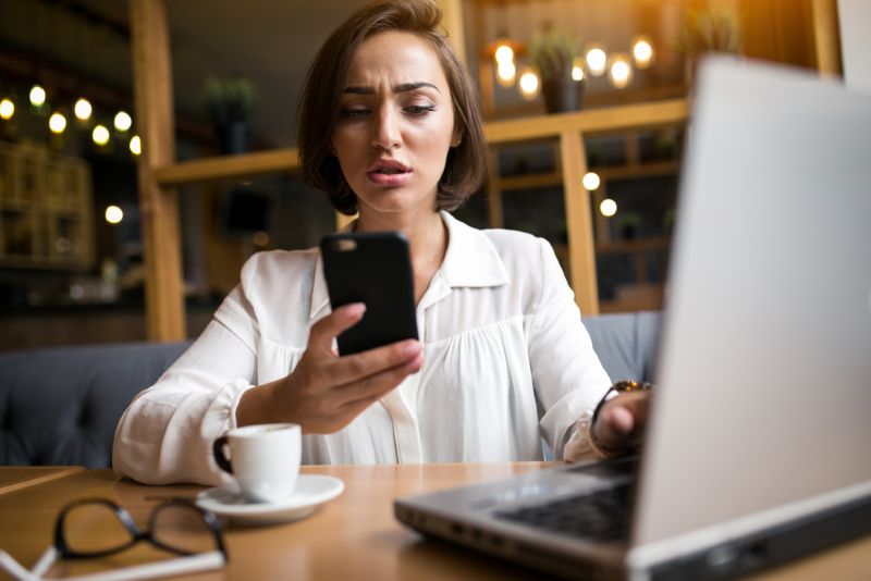 confused woman upset looking at her phone